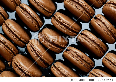 Chocolate-flavored French macaroons are in the bakery. Chocolate-flavored French macaroons are in the bakery. 70858664