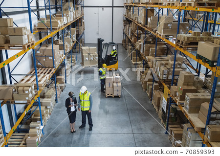 Top view of group of workers with manager indoors in warehouse, coronavirus concept. Top view of group of workers with manager indoors in warehouse, coronavirus concept. 70859393