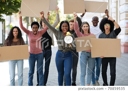 International demonstrators striking on the street, holding megaphone and placards International demonstrators striking on the street, holding megaphone and placards 70859535
