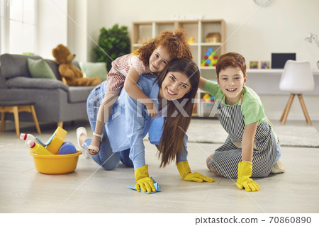 Happy mother with her children cleaning floor at apartment. Parent with kids having fun while doing domestic chores Happy mother with her children cleaning floor at apartment. Parent with kids having fun while doing domestic chores 70860890