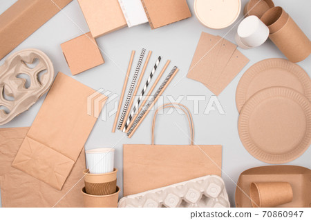 Set of eco-friendly tableware - kraft paper food packaging on light grey background. Street food and fast food paper packaging - cups, plates, straws, containers and paper bags. Flat lay, copyspace Set of eco-friendly tableware - kraft paper food packaging on light grey background. Street food and fast food paper packaging - cups, plates, straws, containers and paper bags. Flat lay, copyspace 70860947