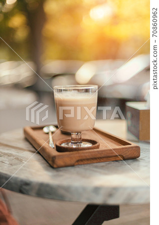 Coffee with milk drink on a wooden tray on a street table in the park Coffee with milk drink on a wooden tray on a street table in the park 70860962