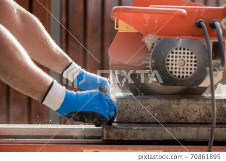 Hands of a person using a circular saw 70861895