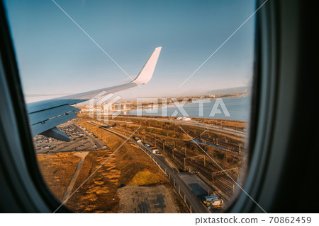Wing of an airplane landing in Kastrup, Copenhagen airport. Wing of an airplane landing in Kastrup, Copenhagen airport. 70862459
