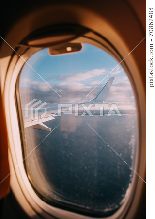 Airplane interior with window view of the Baltic sea and clouds. Airplane interior with window view of the Baltic sea and clouds. 70862483