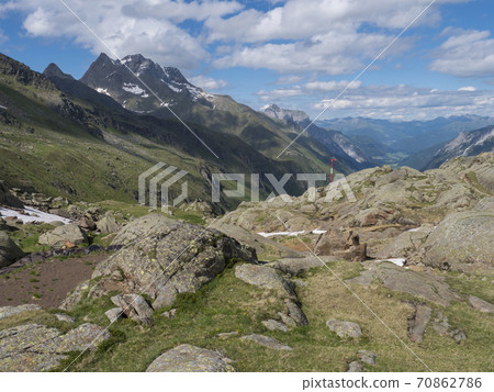 Summer view of Stubai valley from Bremer Hutte at hiking trail, Stubai Hohenweg, rock, boulders and moutain peaks. Tyrol Alps, Austria Summer view of Stubai valley from Bremer Hutte at hiking trail, Stubai Hohenweg, rock, boulders and moutain peaks. Tyrol Alps, Austria 70862786