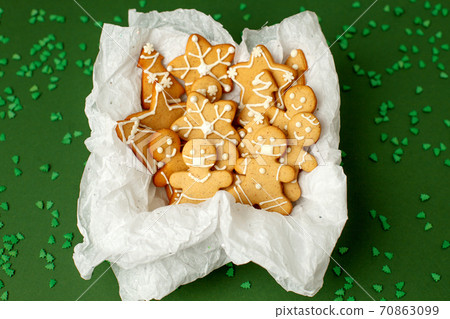 Gift present box with gingerbread man, cookies on natural shades of green background, pandemic new normal, 2021 New Year card, Christmas traditional sweetness, copy space, banner, stay home 70863099