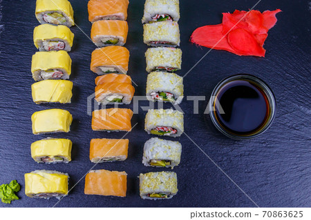 Set of sushi rolls on a black stone slate. Top view 70863625