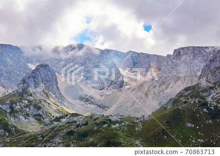 mountain cirque (bowl-shaped valley) with melting glaciers and alpine meadows in the foreground; Mount Fisht, Caucasus mountain cirque (bowl-shaped valley) with melting glaciers and alpine meadows in the foreground; Mount Fisht, Caucasus 70863713