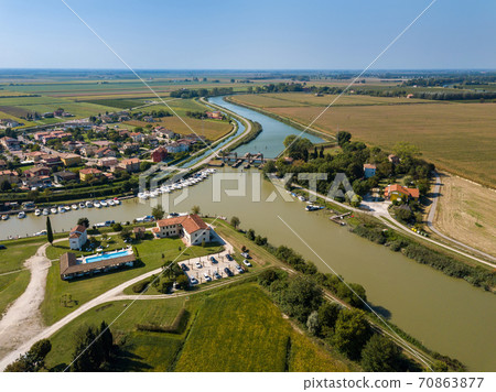 Aerial view on the pitoresque village of Brian near seaside resort Caorle at the Venetian Riviera in Italy with locks and rivers joining the Adriatic Sea further down 70863877