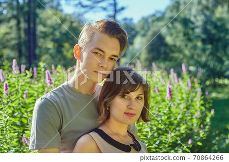 Young man and woman have date in park. 70864266