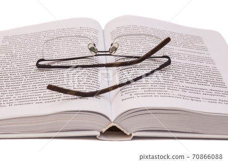 Reading glasses on white open book Reading glasses on white open book 70866088