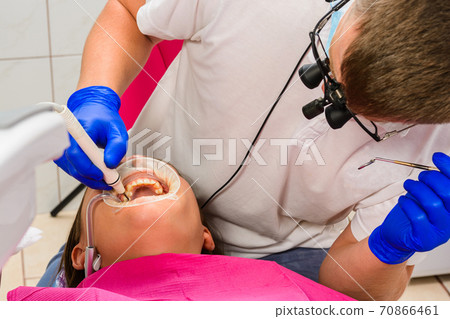 The dentist uses a scaler to remove tartar, oral hygiene. The dentist uses a scaler to remove tartar, oral hygiene. 70866461