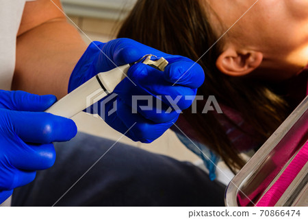 The dentist removes tartar using ultrasound, the patient at the dentist. The dentist removes tartar using ultrasound, the patient at the dentist. 70866474
