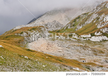 alpine herbaceous foggy landscape with stone fields in place of melted glaciers 70866894