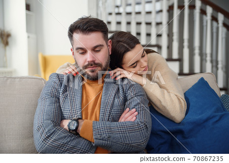 Attractive woman apologizing to frustrated man after quarrel, doubting boyfriend ignore, girlfriend feeling guilty, asking forgive her, begging pardon, admits mistake, regret, couple having problem 70867235