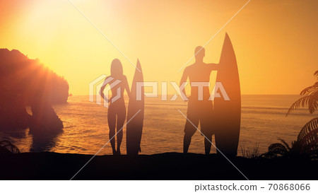 Couple of surfers lit by the setting sun. Couple of surfers lit by the setting sun. 70868066
