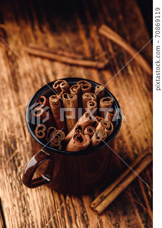 Cinnamon sticks in a metal mug 70869119