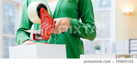 Young woman packing boxes to be shipped Young woman packing boxes to be shipped 70869192