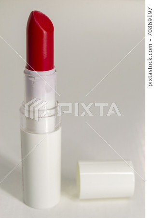 Red lipstick with a white background and cap lying next to it Red lipstick with a white background and cap lying next to it 70869197