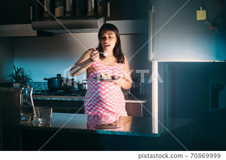 Latin American Pregnant Woman Eating At Night 70869999