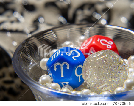 Three fortune-telling dice placed in a tight glass of pearl beads 70870666