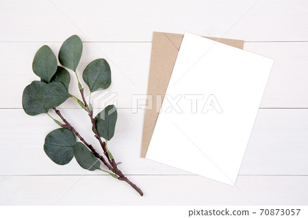 Blank paper sheet copy space with mockup and leaf on wooden table. 70873057