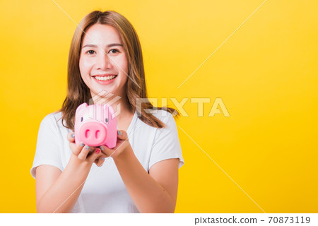 woman smiling hold piggy bank with a lots money woman smiling hold piggy bank with a lots money 70873119