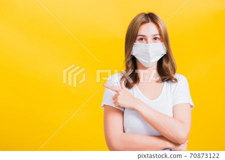 woman wearing face mask protects filter dust pm2.5 anti-pollution, anti-smog, and air pollution her pointing out to side 70873122