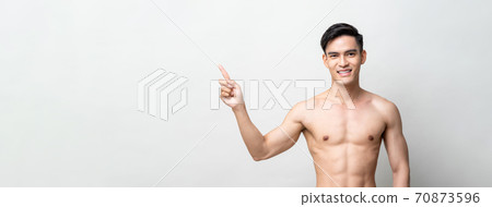 Smile shirtless Asian man pointing hand to copy space aside 70873596