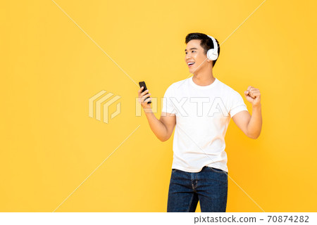 Young handsome Asian man enjoying listening to music from smartphone  70874282