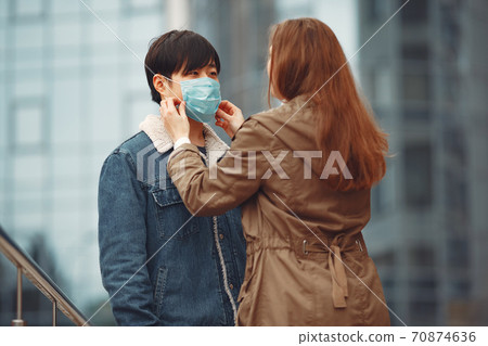 A woman and Chinese man are wearing protective masks 70874636