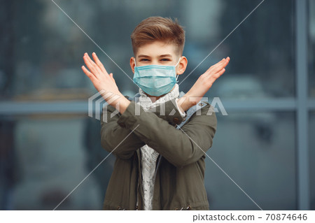 A boy in a disposable mask crossing arms A boy in a disposable mask crossing arms 70874646