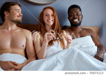 diverse trio making love in bedroom. sex party concept 70875213