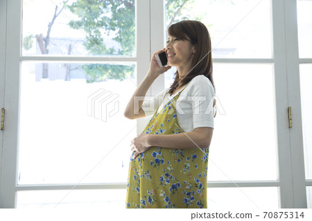 Pregnant woman making a phone call 70875314