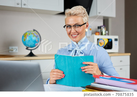stylish blonde caucasian female teacher having online class via video chat on laptop pc stylish blonde caucasian female teacher having online class via video chat on laptop pc 70875835