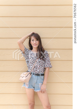 Asian women long hair wearing polka dot dress, jeans shorts Fashion shoulder bag On a wooden background 70876562