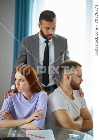 redhead woman and bearded man sit turning away of each other redhead woman and bearded man sit turning away of each other 70876871
