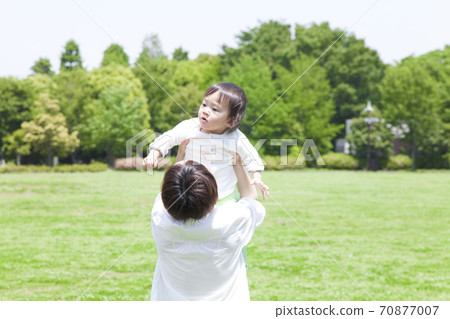 Parent and child playing in the park Parent and child playing in the park 70877007