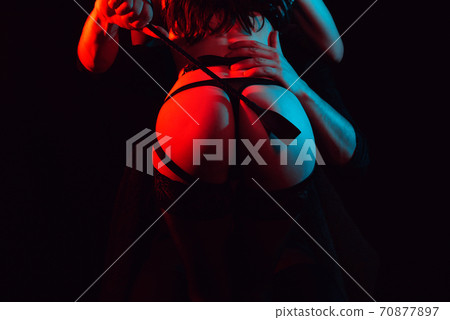 dominant man slaps a leather whip on the big ass of a submissive girl dominant man slaps a leather whip on the big ass of a submissive girl 70877897
