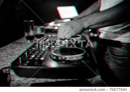 hands on DJ playing music on professional mixer controller in nightclub 70877994