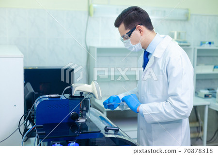 DNA laboratory. The expert puts the human DNA into the database using advanced laboratory technologies 70878318