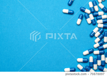 group of pills or capsules on blue background 70878897