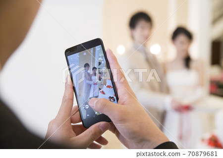 Woman taking a wedding photo 70879681