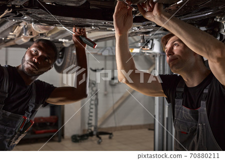 two friendly professional auto mechanic during work 70880211