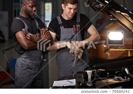 multi-ethnic team of african and caucasian men working in auto service multi-ethnic team of african and caucasian men working in auto service 70880241