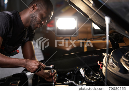 auto mechanic male use wrench and other tools for fixing a car engine auto mechanic male use wrench and other tools for fixing a car engine 70880263