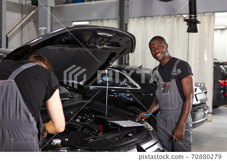 multi-ethnic team of african and caucasian men working in auto service multi-ethnic team of african and caucasian men working in auto service 70880279