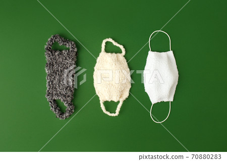 Coronavirus Winter Season concept. Different types of Funny Warming protective face masks on natural shades green background, Winter holiday, cold time self isolation concept Coronavirus Winter Season concept. Different types of Funny Warming protective face masks on natural shades green background, Winter holiday, cold time self isolation concept 70880283