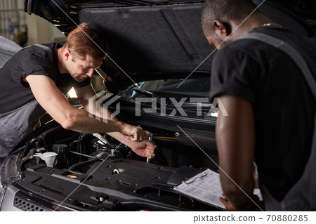 multi-ethnic team of african and caucasian men working in auto service 70880285